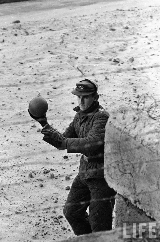 Un soldado a punto de lanzar un balón de vuelta al otro lado del Muro de Berlín